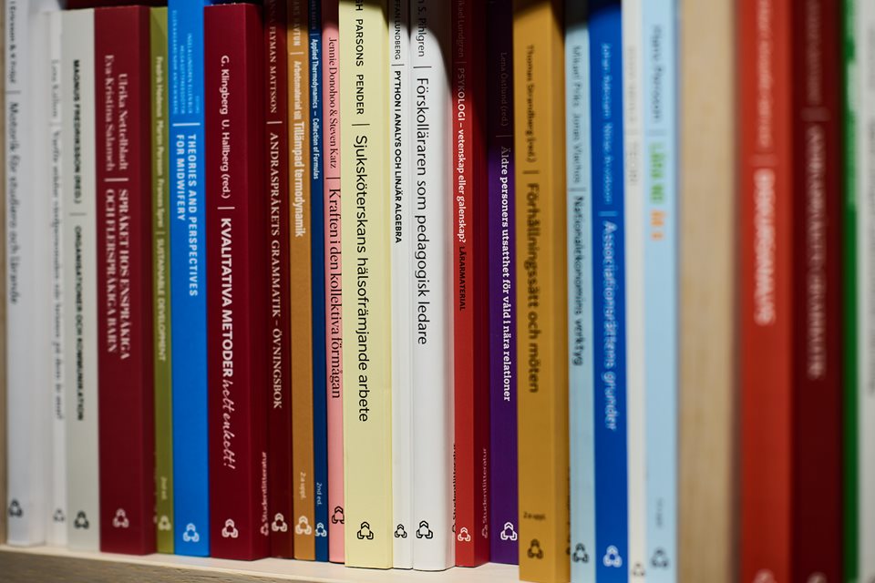 Kurslitteratur utgivna av Studentlitteratur stående i en bokhylla