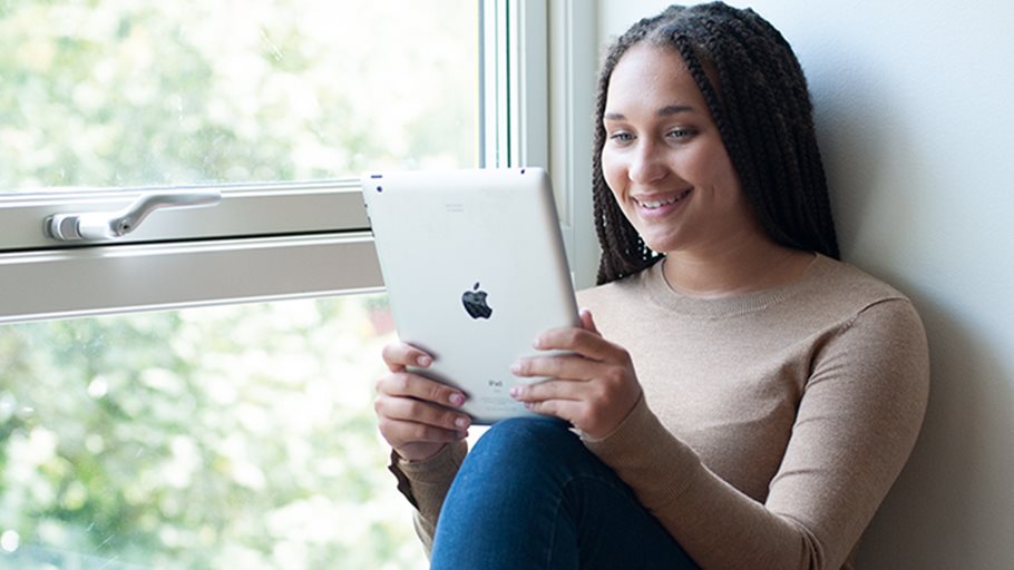 Elev med ipad i fönstersmyg